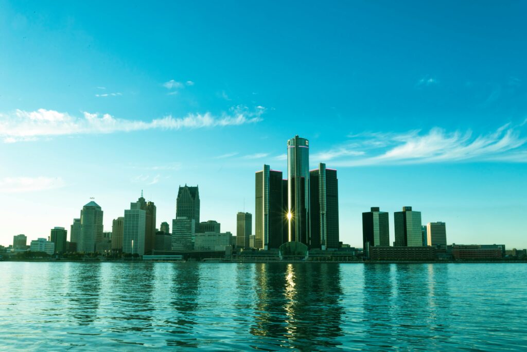 Vue panoramique de la skyline de Detroit, Michigan, avec le Renaissance Center reflétant la lumière du soleil sur les eaux de la rivière Detroit. Centre historique de l'industrie automobile aux États-Unis, Detroit est un hub clé pour l'importation et l'exportation de voitures américaines